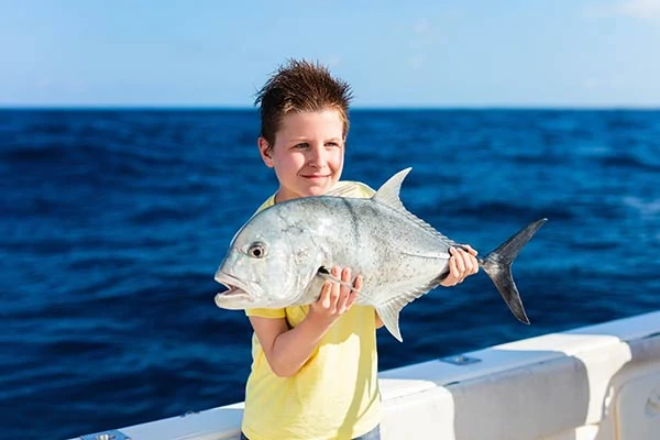Boy holding up his big flat fish catch